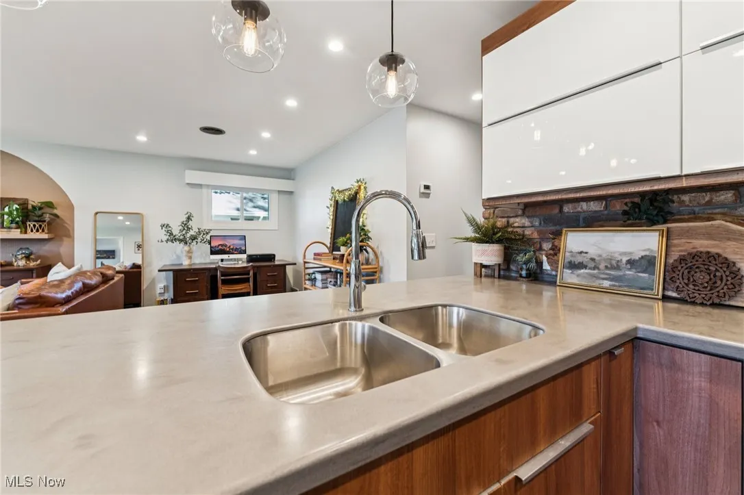 Kitchen with open floor plan, recessed lighting, pendant lighting, white cabinetry, and modern cabinets