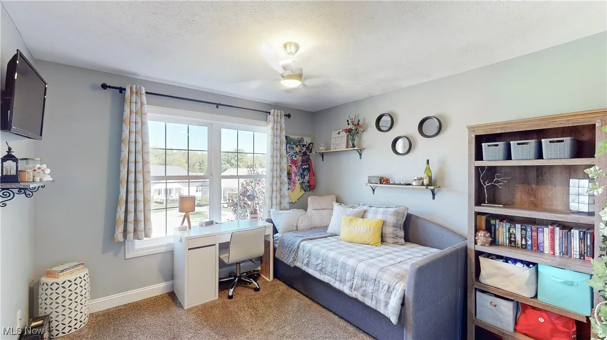 Bedroom with carpet floors, a desk, and a textured ceiling