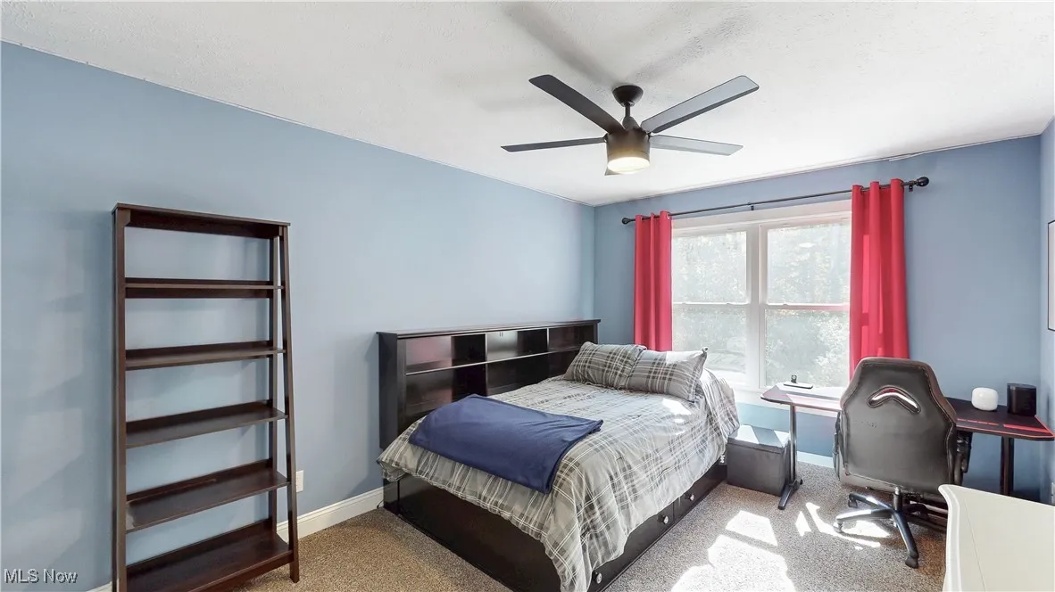 Bedroom with carpet, ceiling fan, an office area, and a textured ceiling
