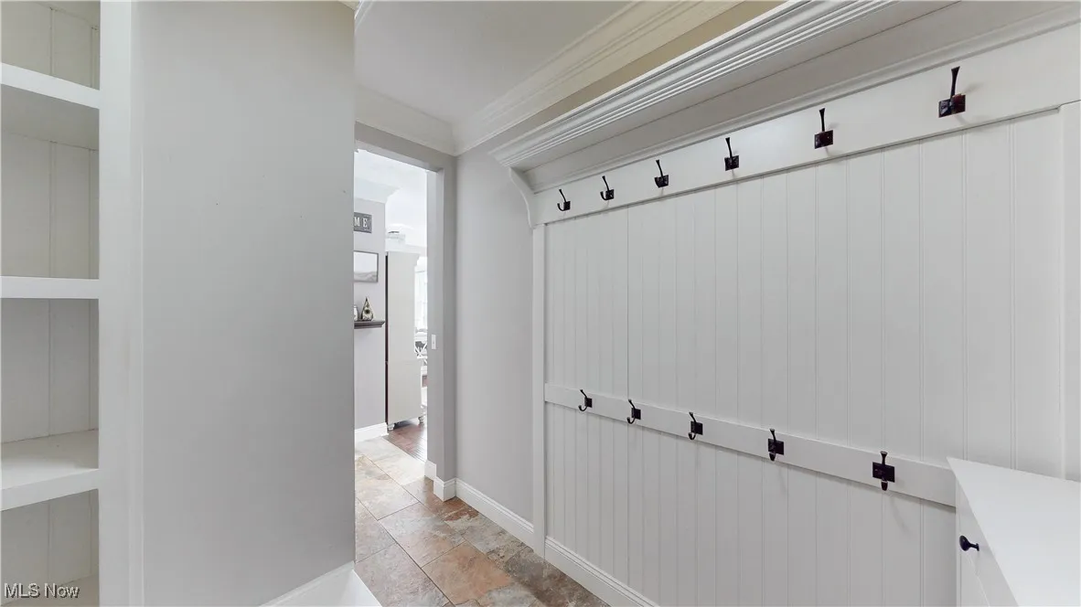 Mudroom featuring ornamental molding and light stone finish floors
