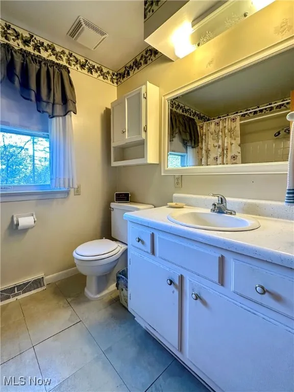 Bathroom featuring vanity, a shower with shower curtain, and light tile patterned flooring
