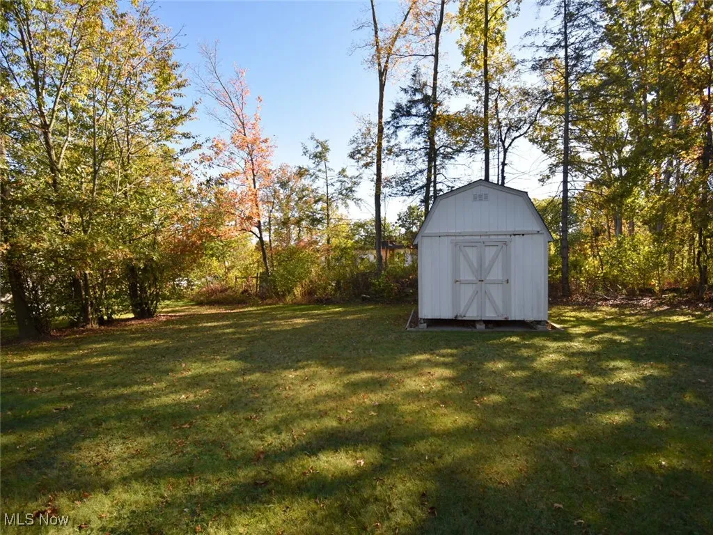 View of grassy yard featuring a storage shed