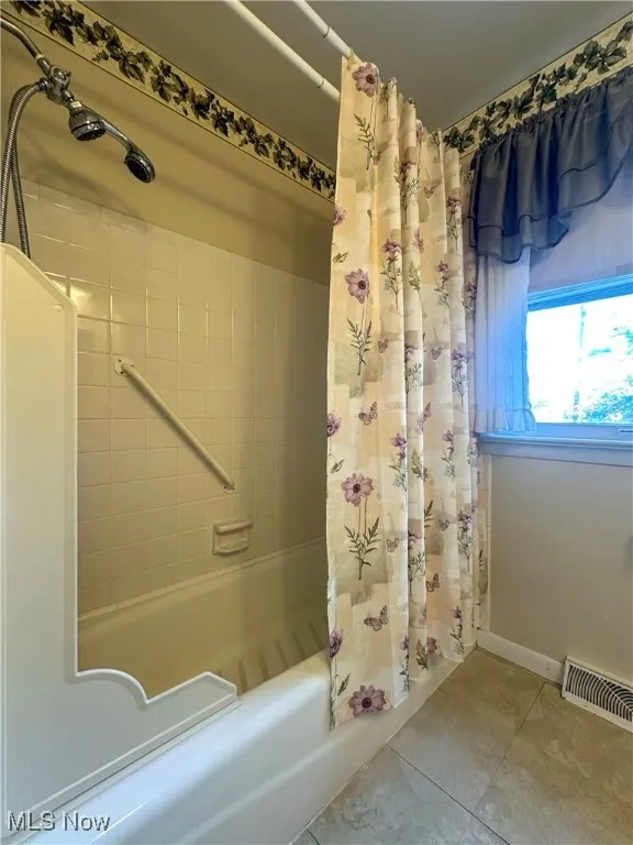 Full bathroom with tile patterned flooring and shower / tub combo
