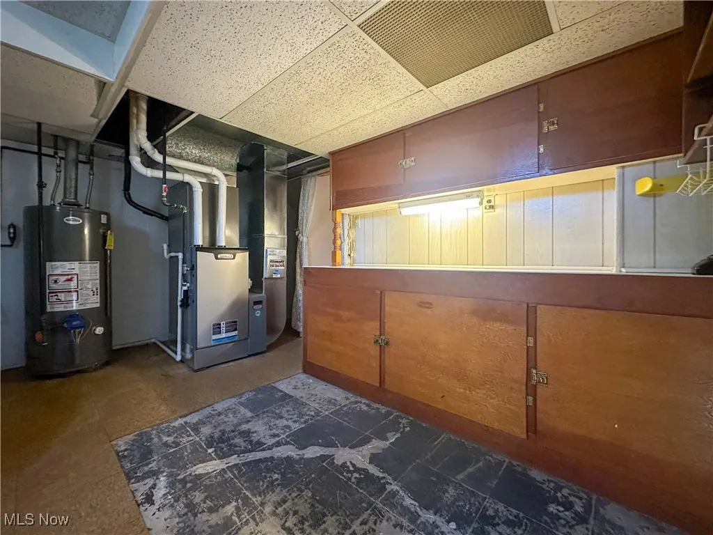 Utility room with gas water heater and heating unit