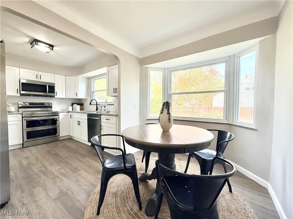 Dining room with light wood-type flooring and baseboards