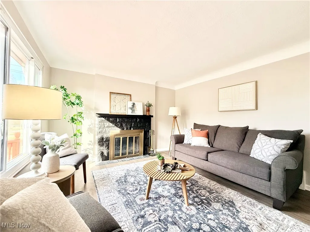 Living room featuring wood finished floors and a glass covered fireplace