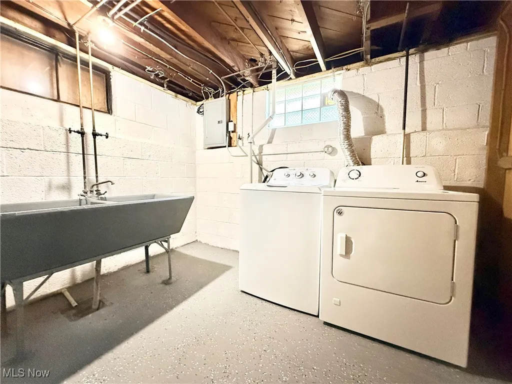 Laundry room featuring electric panel and washing machine and dryer