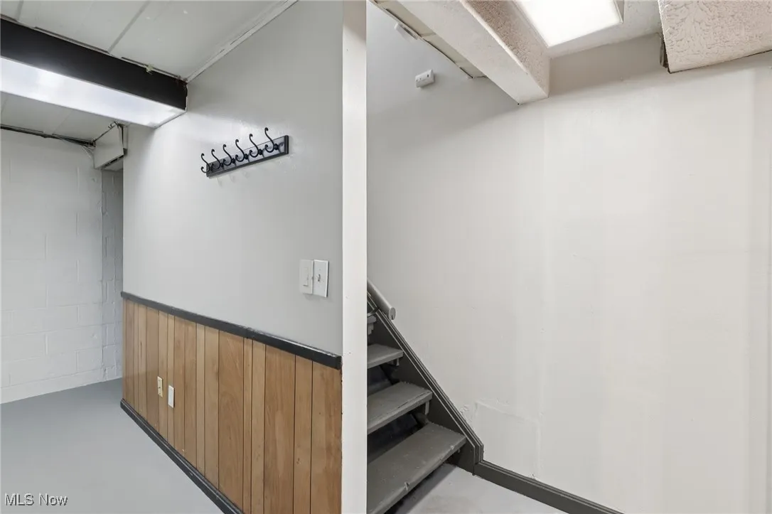 Stairs featuring finished concrete flooring and wood walls