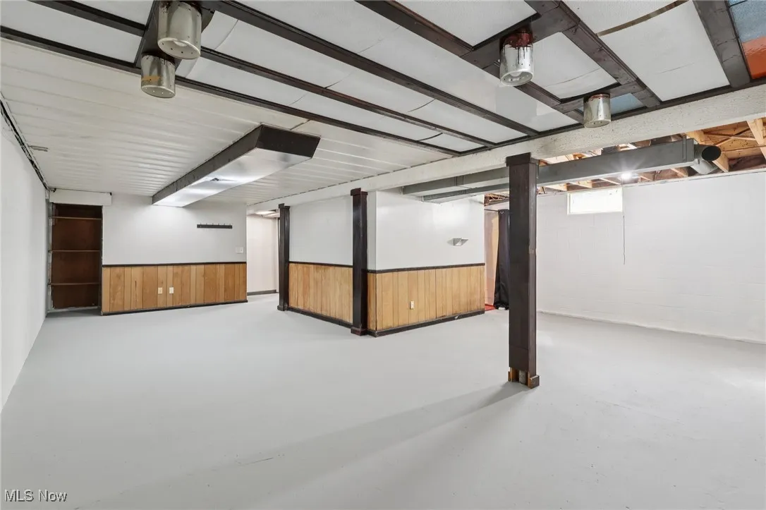 Below grade area featuring wood walls and wainscoting