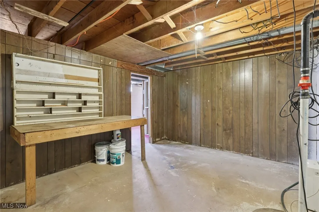 Unfinished basement featuring wood walls