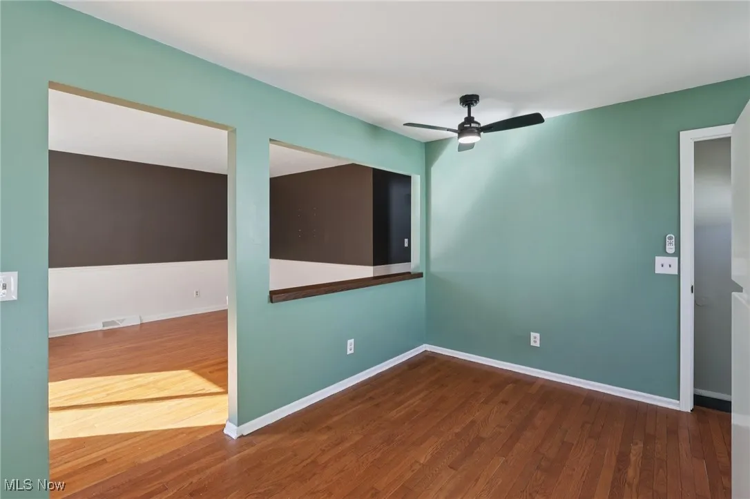 Spare room featuring dark wood-type flooring and a ceiling fan