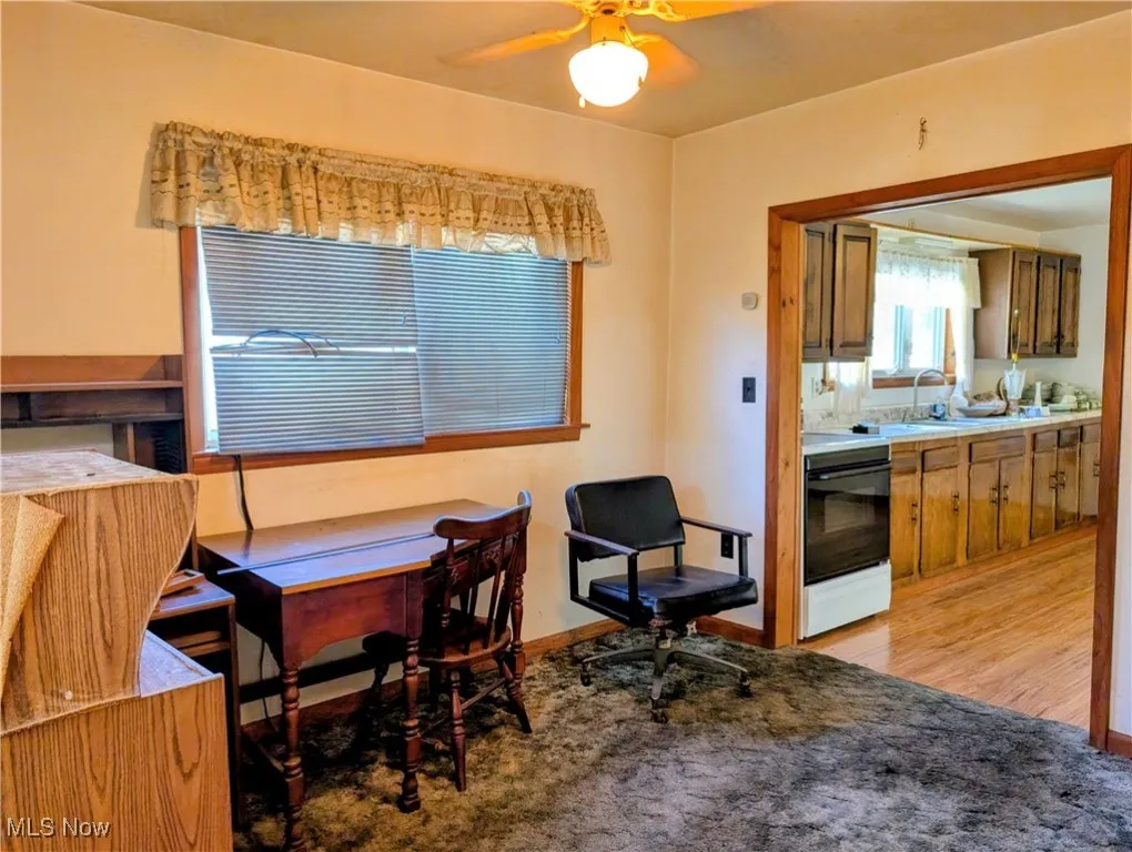 Dining space with a ceiling fan and light carpet