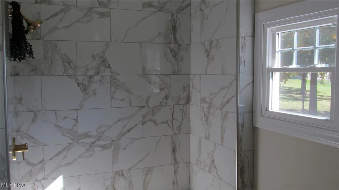 Bathroom with a marble finish shower