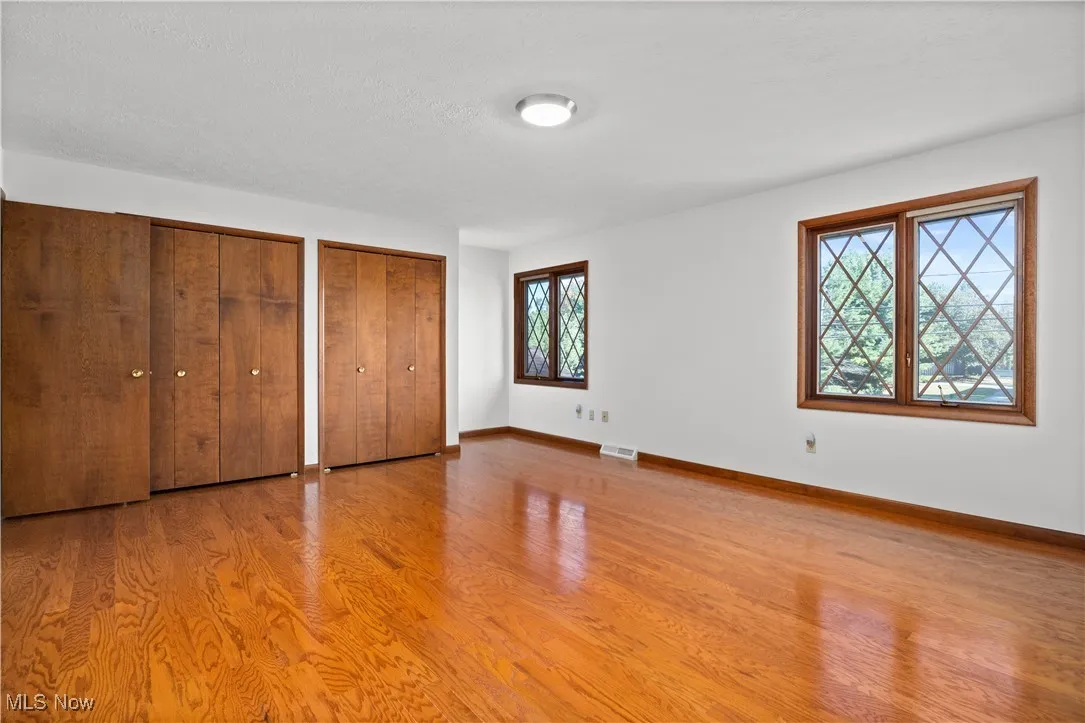 Unfurnished bedroom with two closets and light wood-style flooring
