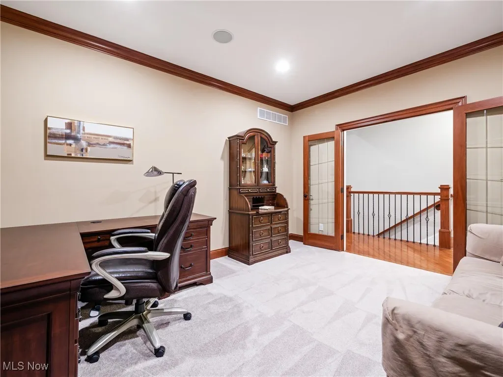 Office with ornamental molding and light colored carpet