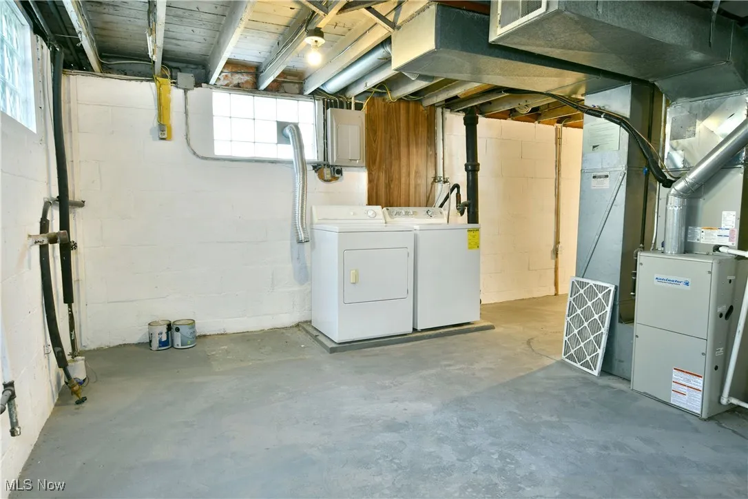Below grade area featuring separate washer and dryer and heating unit