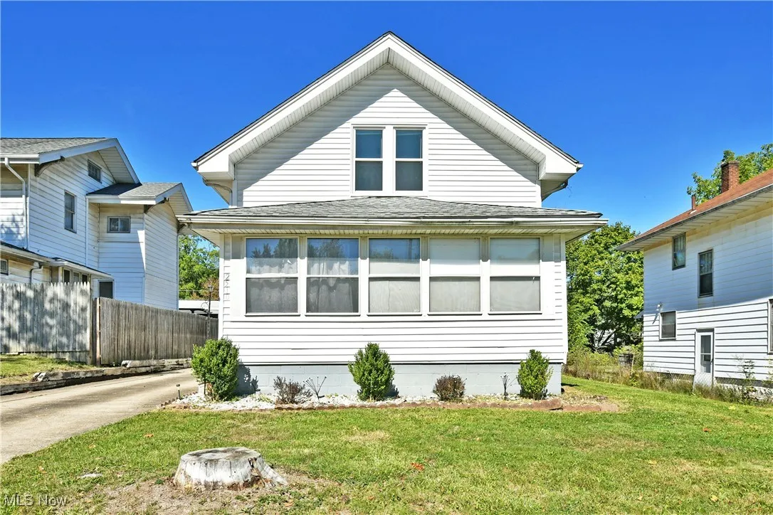 Rear view of house with roof with shingles and a lawn