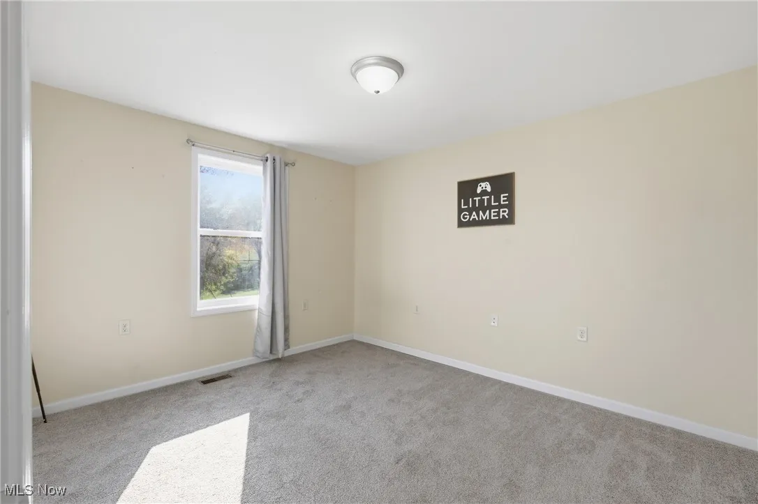 Carpeted empty room featuring baseboards