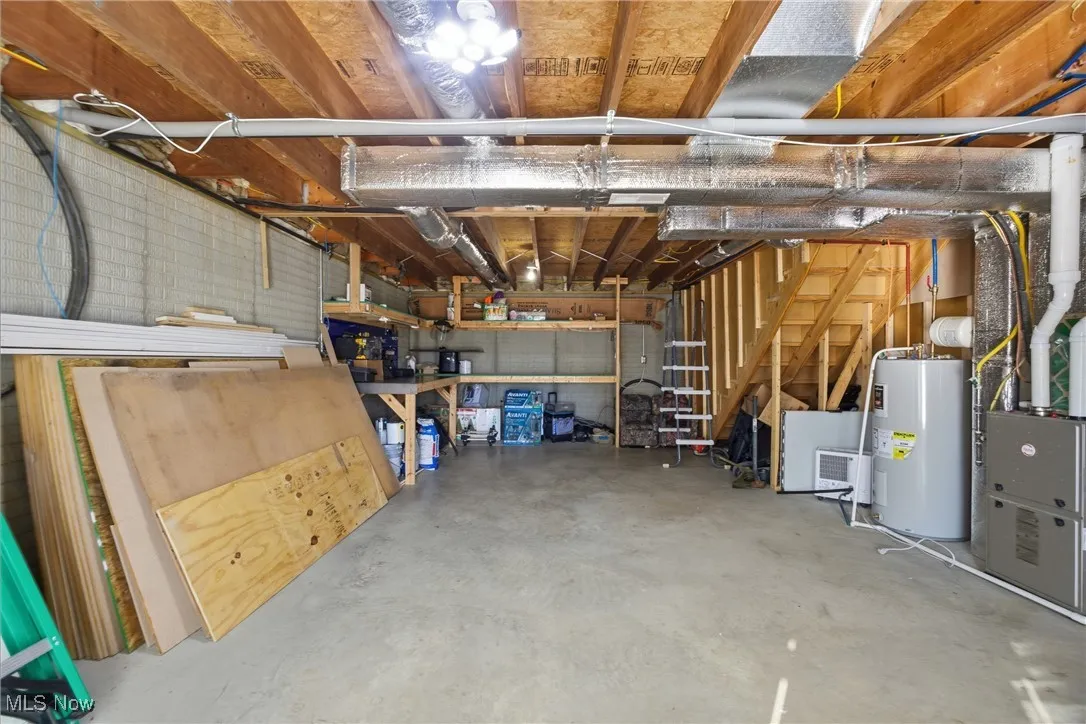 Garage featuring electric water heater and heating unit