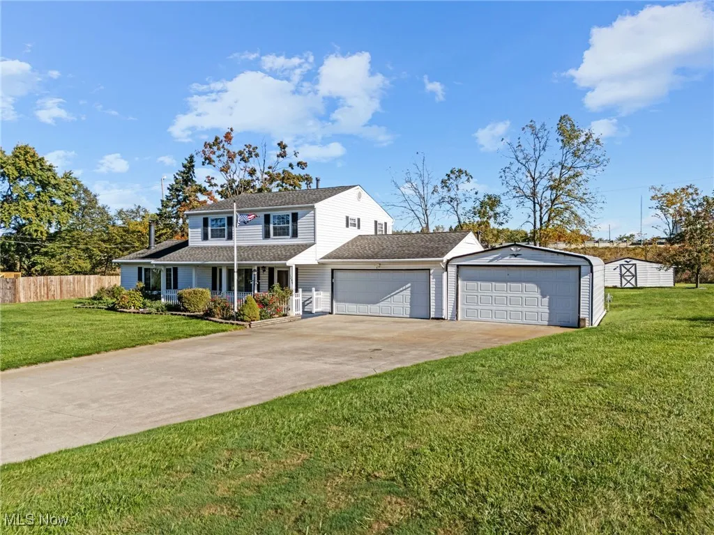 View of front of home with covered porch, driveway, roof with shingles, and an attached garage