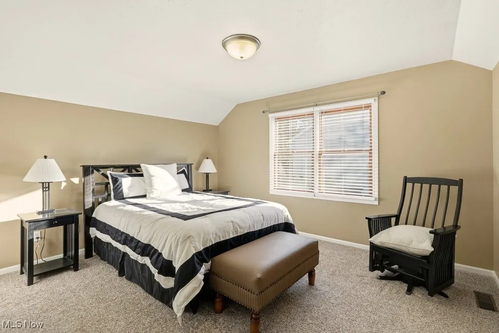 Bedroom featuring lofted ceiling and light colored carpet
