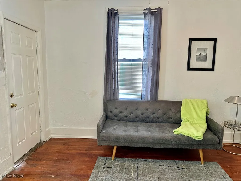 Sitting room featuring baseboards and dark wood-style floors