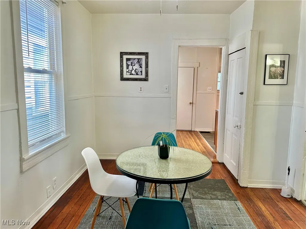 Dining space featuring dark wood-style flooring and baseboards