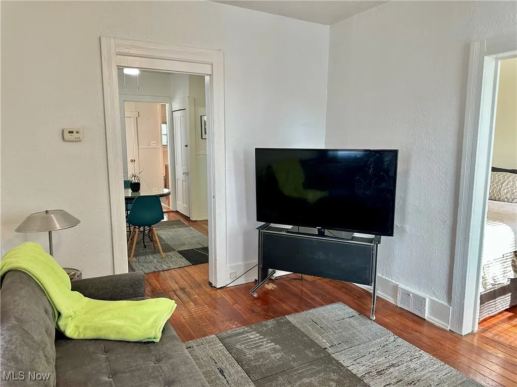 Living area featuring a textured wall and dark wood-style floors