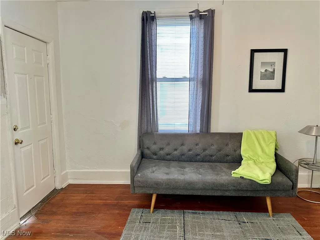 Sitting room with baseboards and dark wood-style flooring