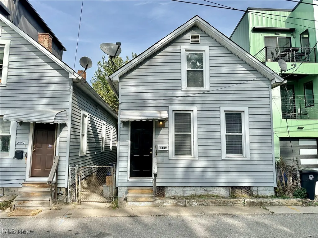 View of front of home featuring entry steps, a gate, and a balcony