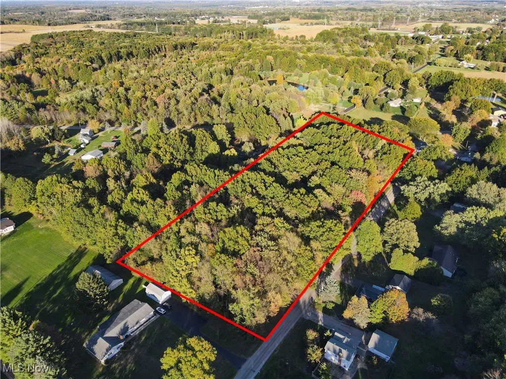 Aerial view of property and surrounding area with a forest and property boundaries highlighted