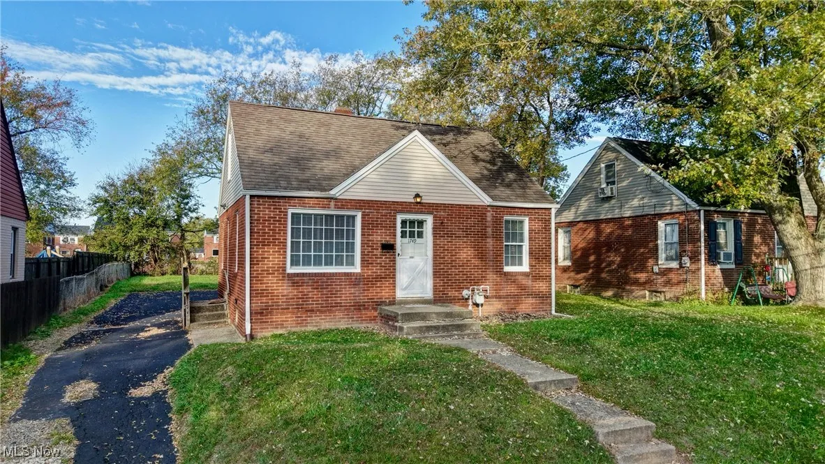 Bungalow featuring brick siding and roof with shingles