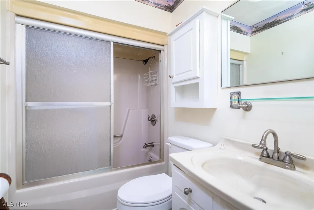 Full bath featuring vanity and combined bath / shower with glass door