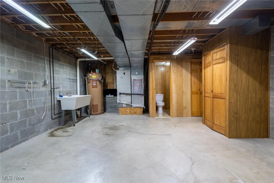Unfinished basement with heating unit and water heater