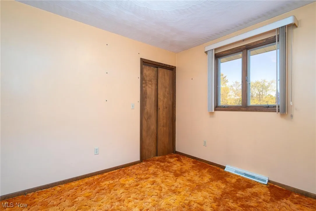 Spare room featuring a textured ceiling and baseboards