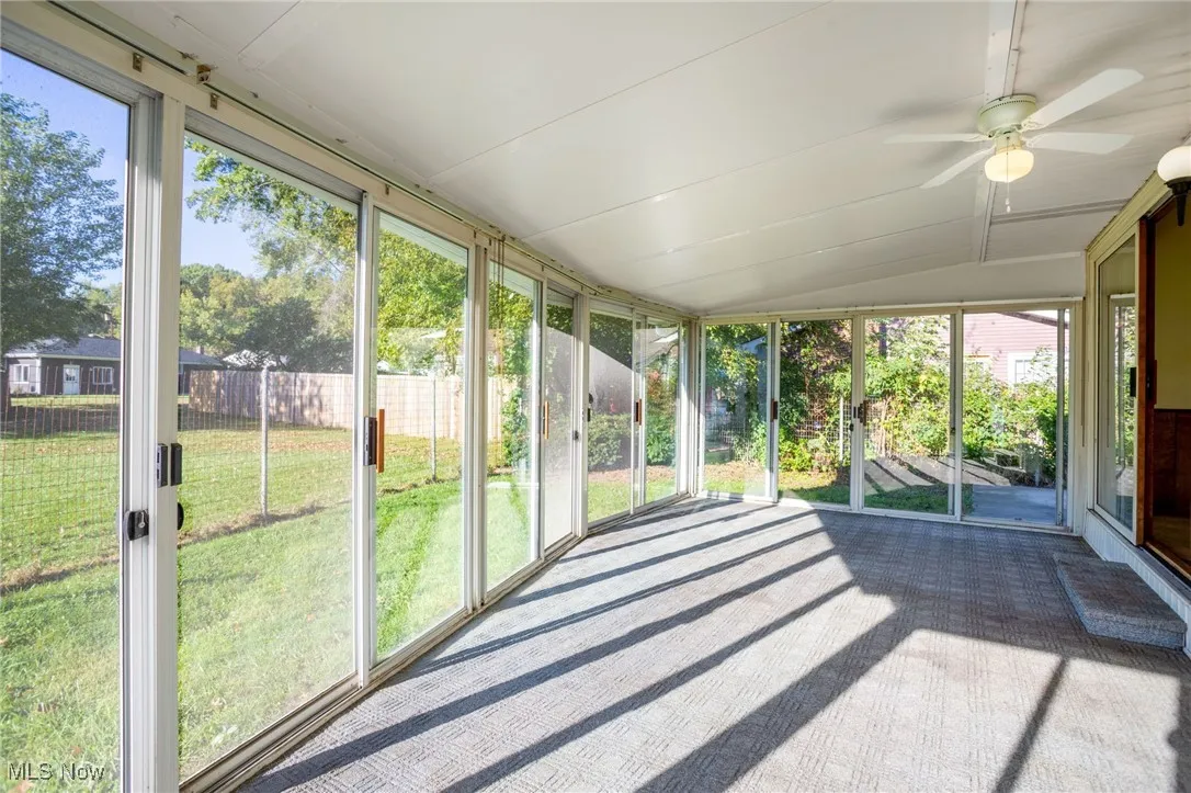 Unfurnished sunroom featuring ceiling fan and lofted ceiling