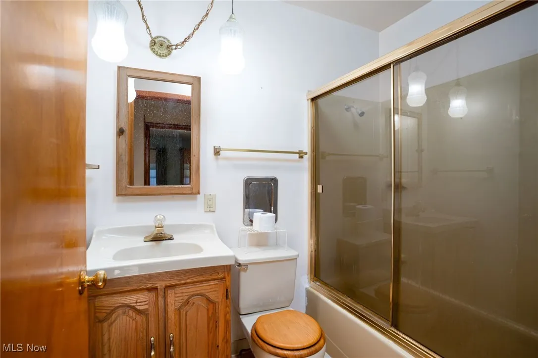 Bathroom featuring vanity and combined bath / shower with glass door