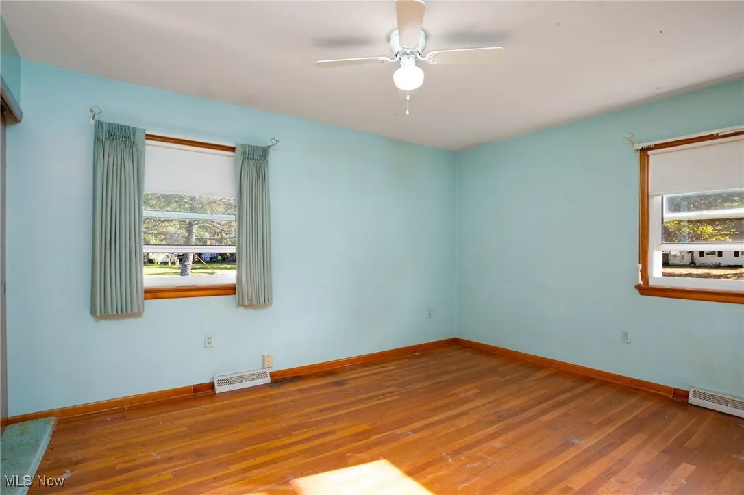 Unfurnished room with wood finished floors and a ceiling fan