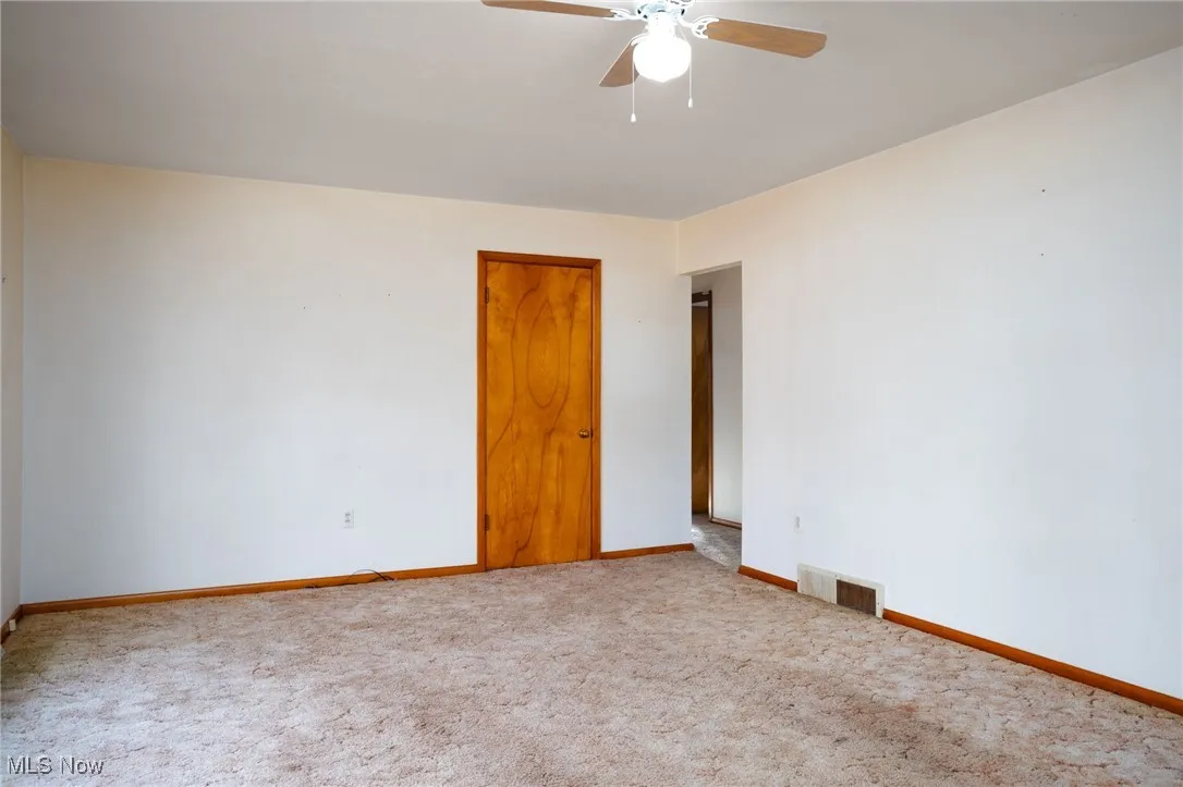 Spare room featuring carpet floors and a ceiling fan
