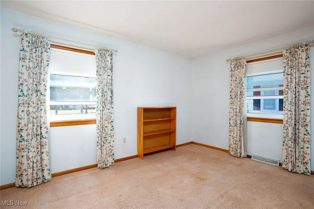 Unfurnished room with light colored carpet and baseboards