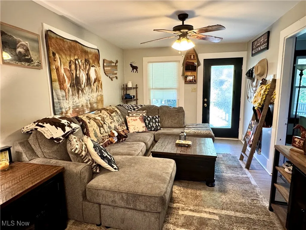 Living room featuring wood finished floors and a ceiling fan