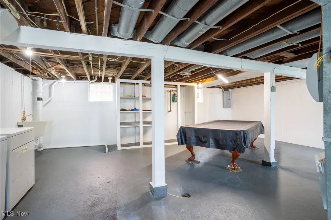 Basement featuring billiards table, electric panel, and washing machine and clothes dryer