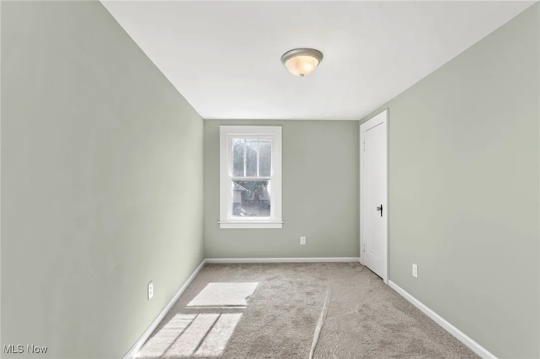 Carpeted empty room featuring baseboards