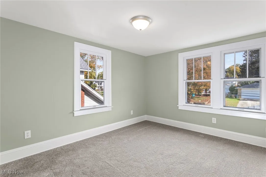 Carpeted spare room featuring baseboards