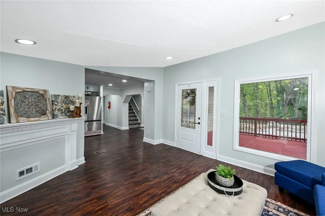 Foyer entrance featuring dark wood finished floors, recessed lighting, stairway, and a textured ceiling
