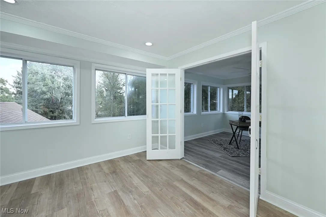 Spare room with ornamental molding, light wood finished floors, and recessed lighting