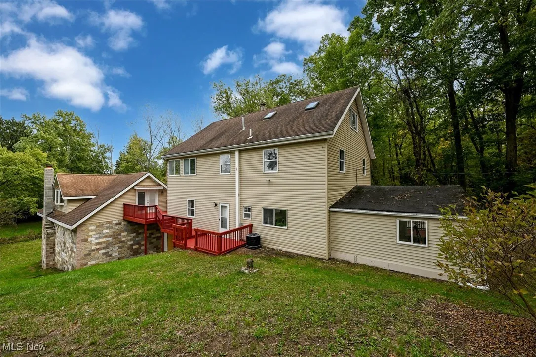 Back of property with a deck and a yard