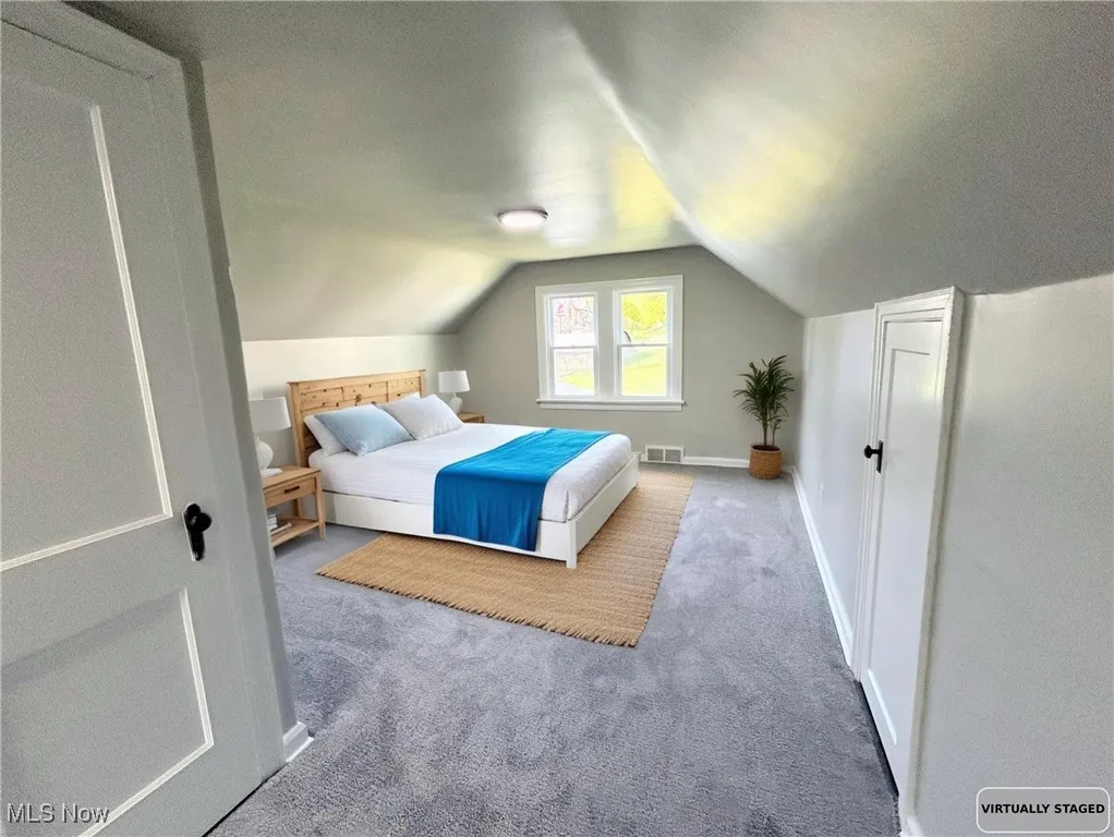 Bedroom with carpet flooring and vaulted ceiling