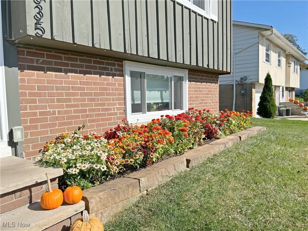 View of property exterior with a yard and brick siding
