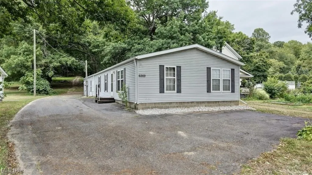 View of property exterior with view of wooded area